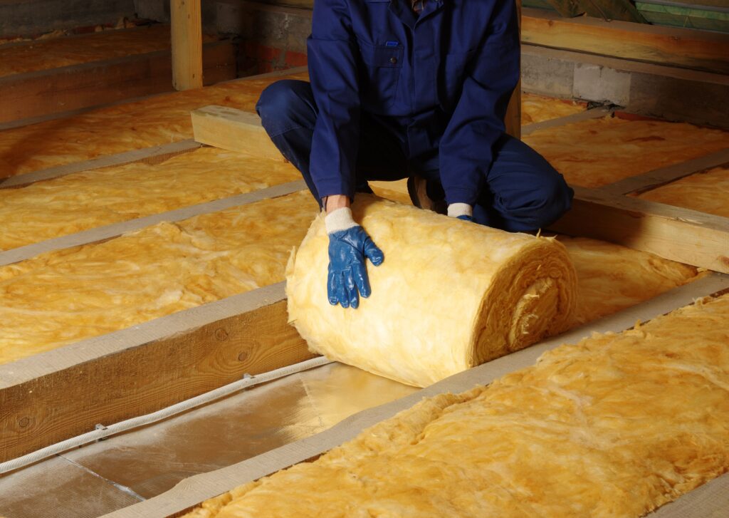Image of a person putting insulation in attic